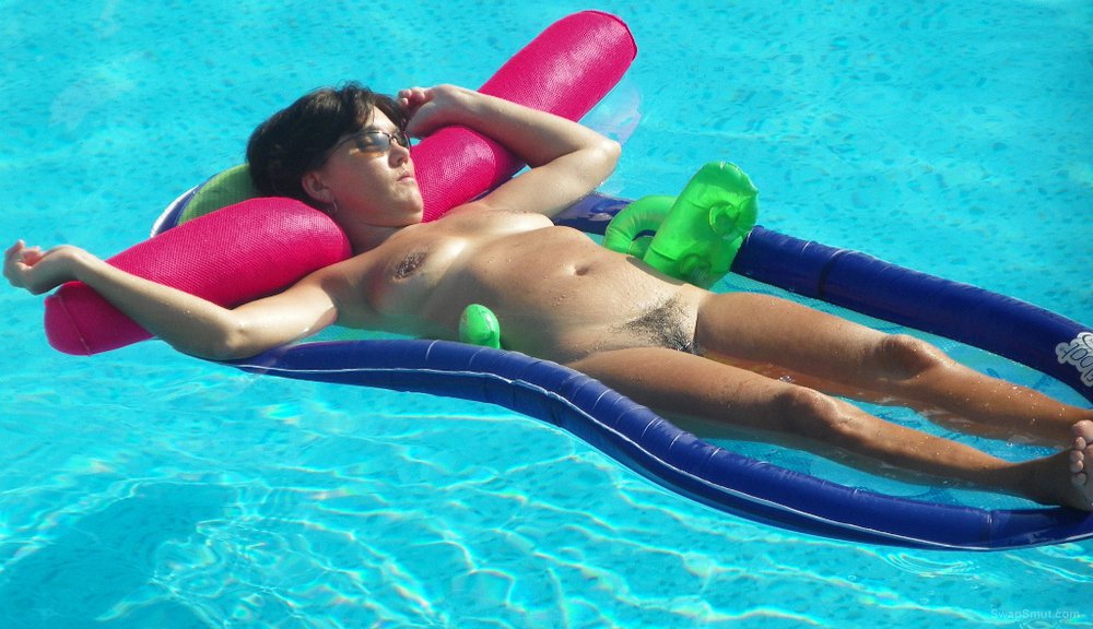Nude wife for all to see and enjoy relaxing on inflatable in pool