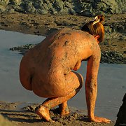 Spying mature woman at the beach early morning covered in mud