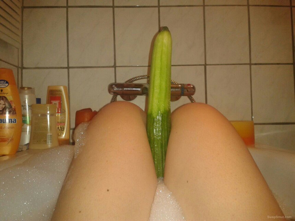 Milf is playing with cucumber in the bathtub