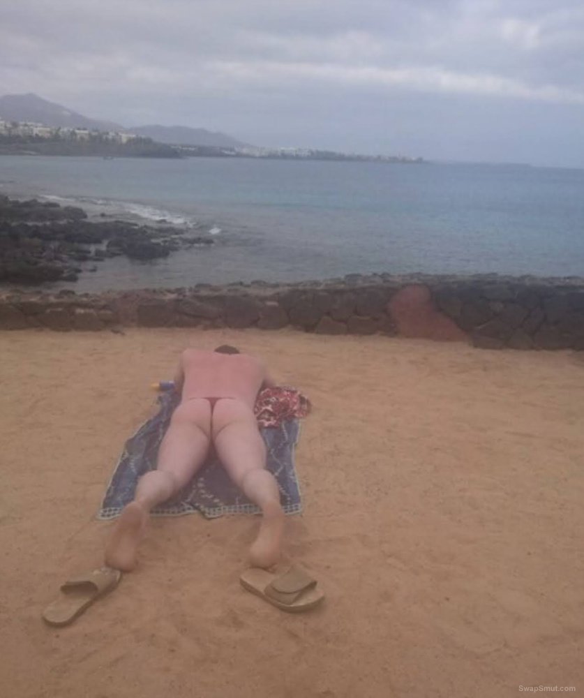 Male sunbathing in new beach thong on public beach